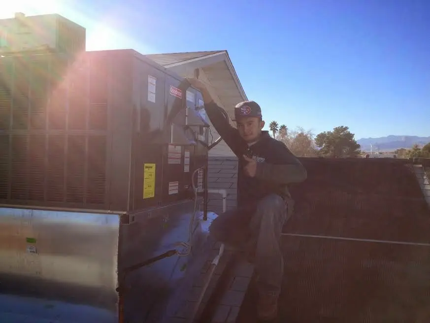 HVAC technician performing Air Duct Repair on a rooftop unit in Agawam Town
